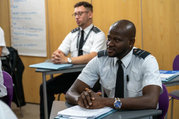 Male prison officers sitting in classroom at training
